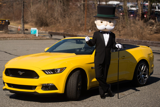 Mr. Monopoly posing with the Ford Mustang