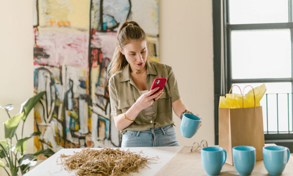 Girl taking picture of blue ceramic mug