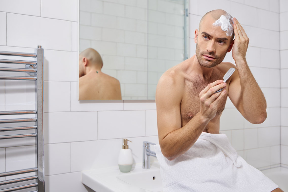 Man shaving his head with straight razor
