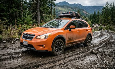 Orange 2015 Subaru Crosstrek driving down a dirty road